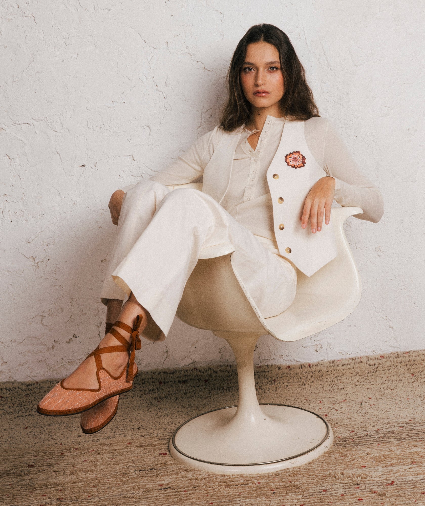 Mujer sentada, vestida de un conjunto de lino de Sveti Stefan